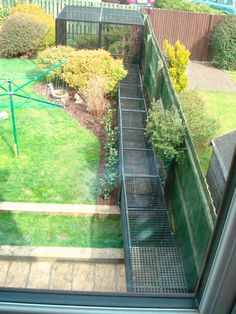 the view from inside a house looking down at a garden and stairs leading up to an open door