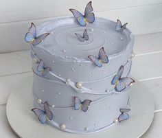 a white cake with blue butterflies on it