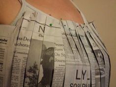 a woman's stomach is covered with newspapers and has her hands on her hips