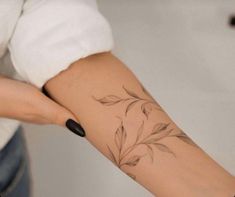 a woman's arm with a flower tattoo on the left side of her arm