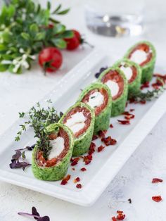 three appetizers are arranged on a plate with garnishes and herbs