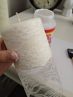 a person is holding a candle with lace on it