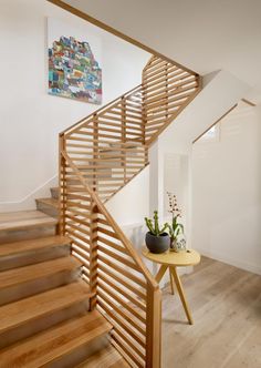 there is a wooden stair case in this house with white walls and wood flooring