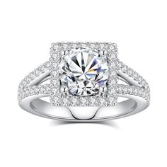 a round cut diamond surrounded by pave set diamonds on top of a white gold ring