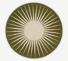 a green and white circular rug with sunbursts on the center, in front of a white background