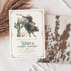 an animal print is on the cover of a birth announcement card, next to a fake cactus