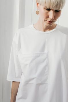 White cotton T-shirt with an ornamental, exaggerated pocket. Sleeves lowered and slightly longer than usual. Oversized in form.The neckline finished off with a binderColor: whiteFabric: 92% cotton, 8% elastane (produced in Poland) Wash in a washing machine in 30-40 degrees CelsiusThe model (176 cm) is wearing M/LSizes:XS/SBust: 114 cm Total length: 66 cmSleeve length: 33 cmM/LBust: 120 cm Total length: 68 cmSleeve length: 34 cm Big Pocket, Minimalist Wardrobe, Summer Jacket, Beautiful Skirts, Black Linen, Oversized T Shirt, Etsy Fashion, White T Shirt, White Fabrics