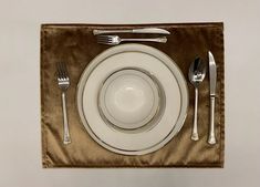 a place setting with silverware and napkins on a velvet tableclothed place mat