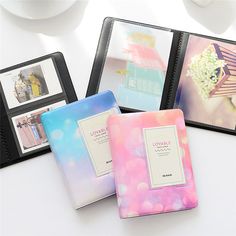 three different colored binders sitting on top of a white table next to each other