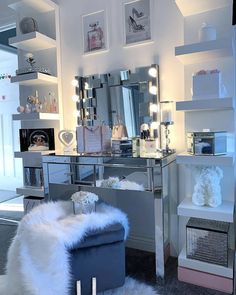 a room with a vanity, mirror and stool in it