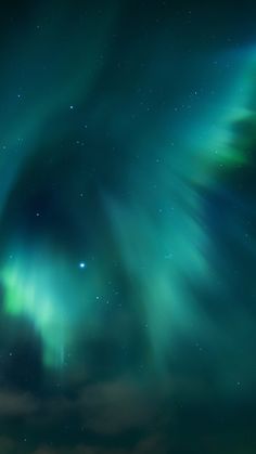 the sky is filled with green and blue aurora bores as well as stars in the night sky