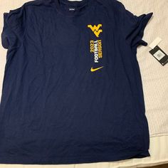 a t - shirt with the word west virginia on it is laying on a bed