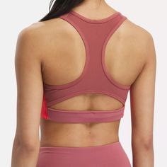 This Reebok sports bra offers medium support for spin class or personal training sessions. It has a pullover design, with removable pads for shaping and coverage. Angled side seams give you stability and support. When it's time to up the intensity, Speedwick tech helps wick sweat away from your skin. Pink Activewear With Built-in Padding For Light Sports, Pink Athletic Fit Sports Bra, Sweat Resistant, Supportive Pink Activewear With Built-in Padding, Pink Athletic Fit Sweat-resistant Activewear, Stretch Color Block Sports Bra, Pink Breathable Sports Bra For Sports Events, Pink Racerback Sports Bra With Athletic Fit, Pink Breathable Sports Bra, Pink Athletic Fit Racerback Sports Bra