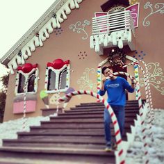 a man standing in front of a building decorated with candy canes