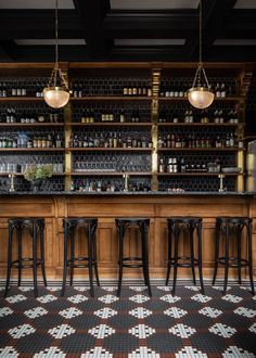 the bar has several stools in front of it and shelves with bottles on them