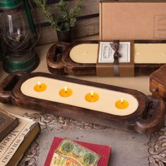 some candles are sitting in wooden trays on a table