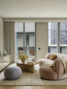 a living room filled with furniture and large windows