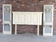 two white doors are in front of a brick wall