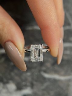 a woman's hand holding an engagement ring