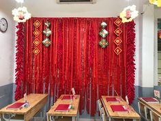 a room with red curtains and wooden tables in front of the wall is decorated with decorations