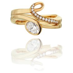 two gold rings with diamonds on them and one diamond in the middle, set against a white background