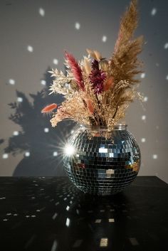 a disco ball vase with dried flowers in it