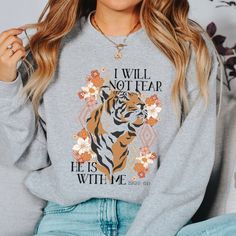 "Featuring the words \"I will not fear He is with me Isaiah 41:10\" printed on a soft fleece sweater! Christian Sweatshirt Reads: I will not fear He is with me Isaiah 41:10 Incredibly soft and durable 50% cotton, 50% polyester US Unisex S-2XL See size chart in the photos above Hand-printed just for you SIZING This sweatshirt is a unisex fit. Not sure of your size? Measure your favorite sweater's width (armpit to armpit) and then the length (top to bottom). HOW TO LOVE YOUR SWEATER Turn the garment inside out and wash cold on a delicate cycle. Lay flat to dry. Do not bleach, dry clean, or iron directly onto the design." Inspirational Long Sleeve Sweatshirt With Graphic Print, Inspirational Graphic Print Sweatshirt For Fall, Fall Inspirational Graphic Print Sweatshirt, Inspirational Graphic Print Fall Sweatshirt, Boho Christian, Girl God, Sweatshirt Trendy, Christian Sweatshirt, How To Love