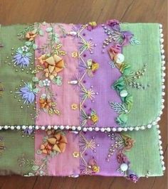 a close up of a piece of cloth on a table with beads and flowers in it