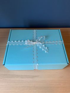 a blue gift box with a white ribbon