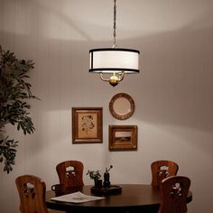 a dining room table with four chairs and a lamp hanging from the ceiling above it