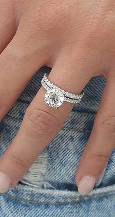 a woman's hand with a diamond ring on her finger and the bottom half of her left hand