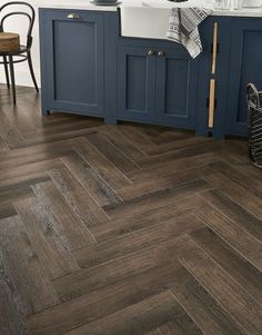 a kitchen with dark wood floors and blue cabinets