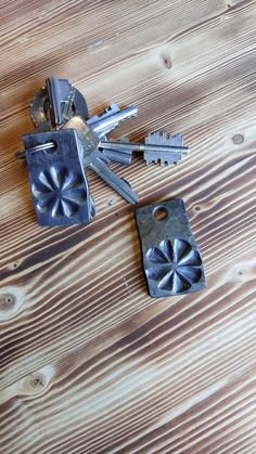 three metal keys laying on top of a wooden table next to two other key pieces