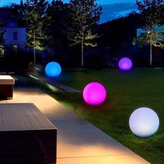 some lights that are sitting on the ground in the grass near a couch and table