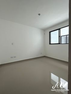 an empty room with white walls and windows