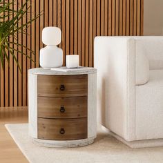 a white chair sitting next to a table on top of a rug in front of a wooden wall