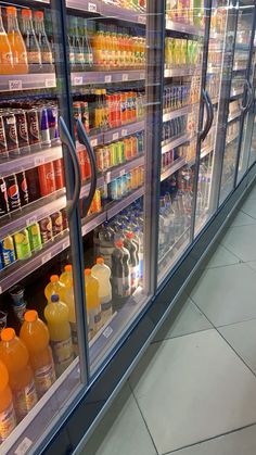 a display case in a grocery store filled with lots of juices and orange drinks