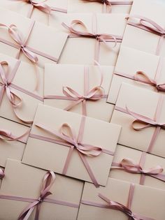 many cards with pink ribbons tied together