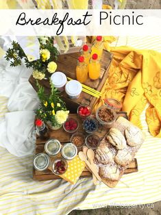 the breakfast picnic is ready to be eaten on the bed with fresh flowers and fruit