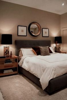 a bedroom with a bed, nightstands and pictures on the wall