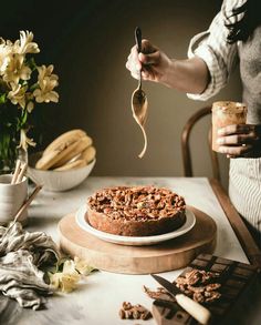 a person holding a spoon over a cake