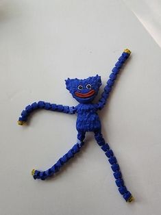 a blue toy is sitting on the floor with its arms and legs spread out to form a man