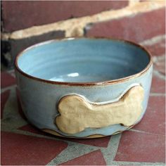 a dog bone bowl sitting on the ground