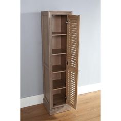 an open wooden cabinet sitting on top of a hard wood floor next to a wall