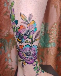 a woman's leg with colorful flowers on it