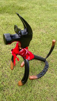 a dog sculpture made out of an old bicycle tire and some scissors on the ground