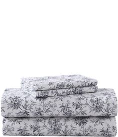 three sheets with floral designs on them, one in white and the other in blue