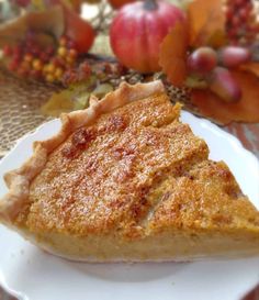 a piece of pie sitting on top of a white plate next to an apple tree