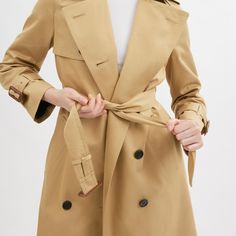 A modern update to a timeless silhouette our lightweight cotton-blend trench is designed with a relaxed fit for easy comfortable wear. Detailed with leather belted cuffs in a nod to our heritage the double-breasted topper is finished with shoulder epaulettes an adjustable belt at the waist and a back vent for ease of movement. | Coach Trench Coat - Women's Size XL - Khaki Spring Business Outerwear With Belted Cuffs, Timeless Gabardine Outerwear For Spring, Elegant Cotton Outerwear With Belted Cuffs, Timeless Outerwear With Belted Cuffs For Work, Timeless Spring Outerwear With Double Button Closure, Classic Outerwear With Belted Cuffs, Classic Double-breasted Outerwear With Belted Cuffs, Timeless Belted Outerwear For Spring, Classic Outerwear With Self Belt