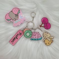 two keychains with different designs on them sitting on a white fur covered surface